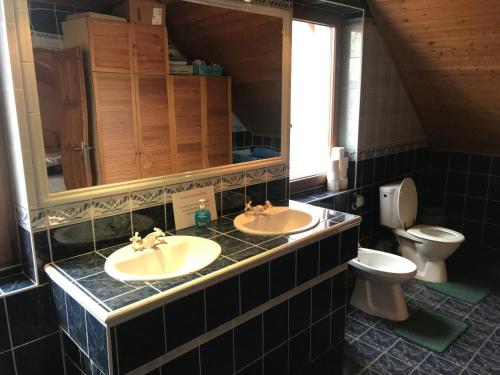 a bathroom with two sinks and a toilet at Koppány Fogadó in Báthorikert