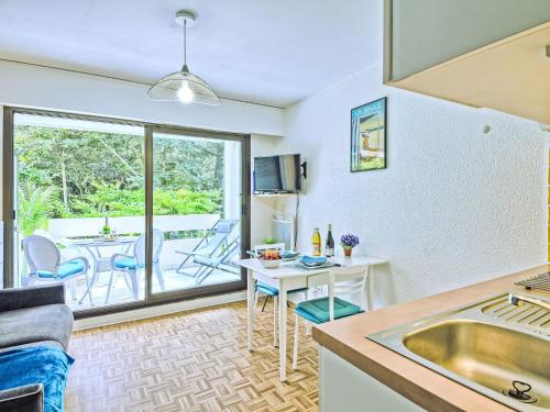 Una cocina y una sala de estar con una mesa. en Apartment La Pomme de Pin by Interhome, en La Baule-les-Pins