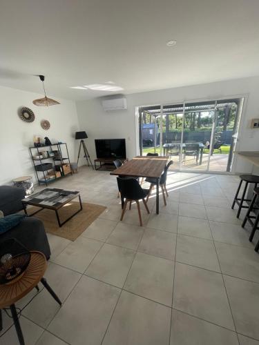 un salon avec une table et des chaises en bois dans l'établissement La pomme de pin, à Mimizan