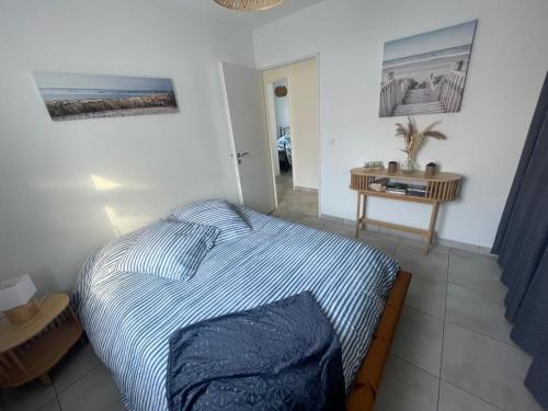 une chambre avec un lit et une table dans l'établissement La pomme de pin, à Mimizan