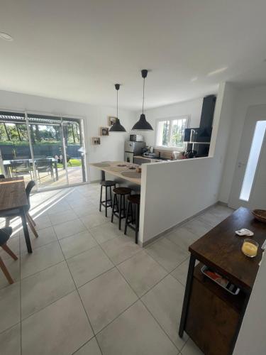 une cuisine et une salle à manger avec une table et des chaises dans l'établissement La pomme de pin, à Mimizan