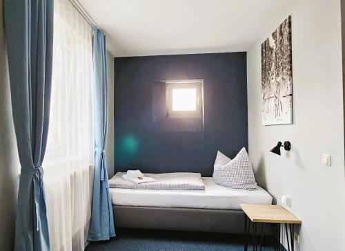 a small bed in a room with a window at ARRIVEL Pension Pliening - bisher Novitel in Pliening