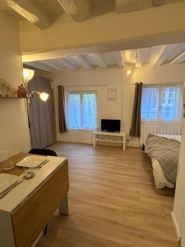 Cette grande chambre comprend un lit, un bureau et une table. dans l'établissement Studio Cosy Beauvoisine, à Rouen