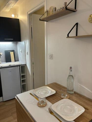 une cuisine avec une table avec des assiettes et des verres dessus dans l'établissement Studio Cosy Beauvoisine, à Rouen