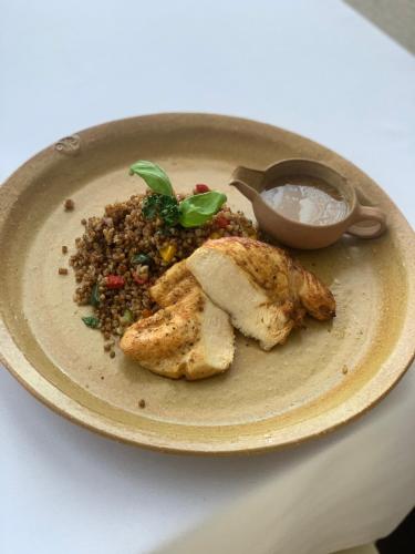 a plate of food with chicken and rice on a table at Lázeňský a Wellness hotel NIVAMARE in Luhačovice