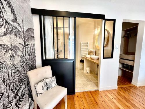 Habitación con puerta, silla y baño. en Chambre Roméo ou Juliette, en Honfleur