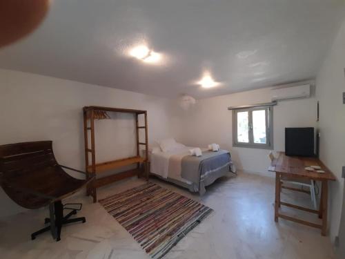 a bedroom with a bed and a desk and a chair at Roses Beach in Parikia