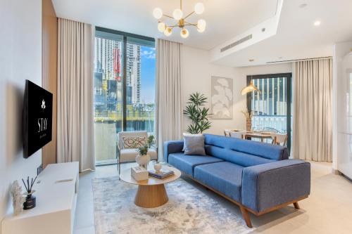 a living room with a blue couch and a table at STAY BY LATINEM Luxury 2BR Holiday Home W204 near Burj Khalifa in Dubai
