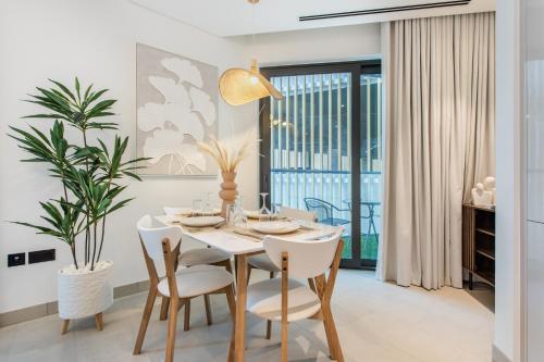 a dining room with a white table and chairs at STAY BY LATINEM Luxury 2BR Holiday Home W204 near Burj Khalifa in Dubai