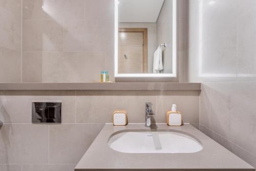 a bathroom with a sink and a mirror at STAY BY LATINEM Luxury 2BR Holiday Home W204 near Burj Khalifa in Dubai