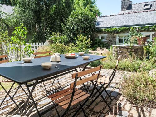 a black table and chairs in a garden at Holiday Home La Dolce Vita Brezhoneg by Interhome in Trémeven