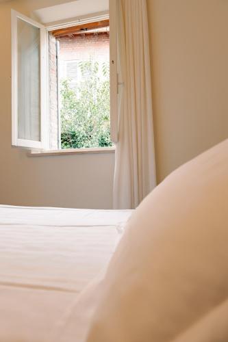 a bedroom with a bed and a window at Urbino Apartment - Urban Retreat in Urbino