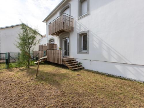 une maison blanche avec des escaliers sur son côté dans l'établissement Apartment Cap Océan-8 by Interhome, à Capbreton