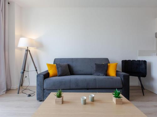 un salon avec un canapé bleu et une table basse dans l'établissement Apartment Cap Océan-3 by Interhome, à Capbreton