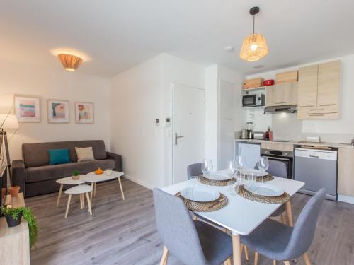 une cuisine et un salon avec une table et des chaises blanches dans l'établissement Apartment Cap Océan-9 by Interhome, à Capbreton