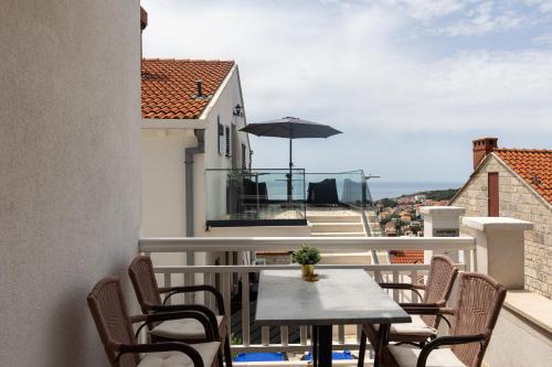 un balcon avec une table, des chaises et un parasol dans l'établissement Guest House Kono, à Dubrovnik