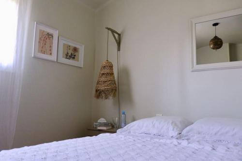 une chambre avec un lit blanc et un miroir dans l'établissement Appartement cosy, à Besançon