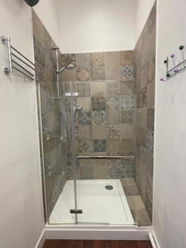 une douche avec une porte vitrée dans une salle de bain dans l'établissement Studio cosy climatisé au coeur du village de Saint Michel l'Observatoire, à Saint-Michel-lʼObservatoire