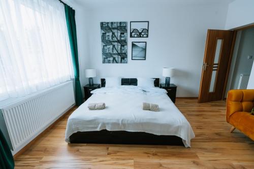a bedroom with a white bed with two pillows on it at Apartamenty Krzywa in Krosno