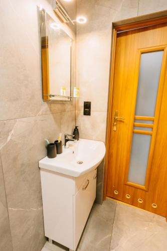a bathroom with a white sink and a mirror at Apartamenty Krzywa in Krosno