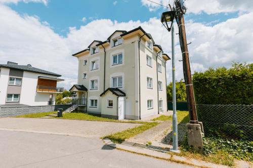 a white building on the side of a street at Apartamenty Krzywa in Krosno