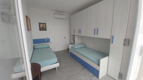 a small room with two beds and white cabinets at vignale holiday house in La Spezia