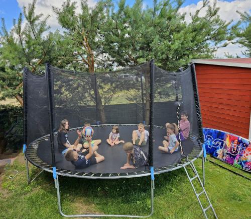 a group of children sitting on a trampoline at GłuszaSpot Dom Freja in Bytoń