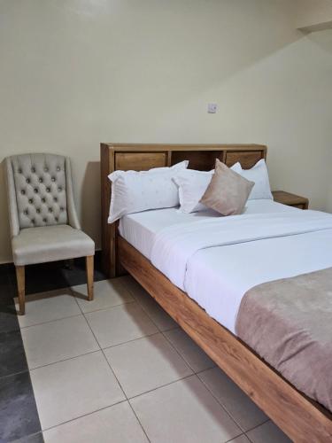 a bedroom with a large bed and a chair at Jsons executive suites in Nairobi