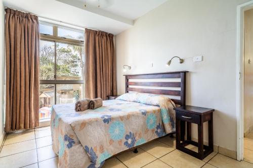 a bedroom with a bed with two stuffed animals on it at ATKV Natalia in Kingsburgh