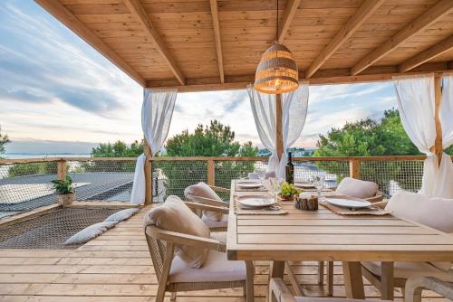 a wooden deck with a wooden table and chairs at Luce mobile homes L1, L2, L3 in Drage