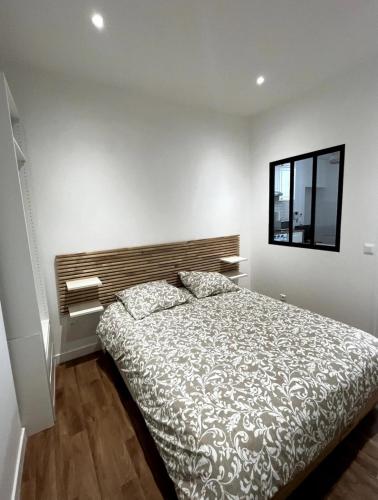 une chambre avec un lit et un miroir au mur dans l'établissement Appartement à deux pas du château à Versailles, à Versailles