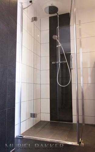 a shower with a glass enclosure in a bathroom at Dijkstra Hotels in Bergen