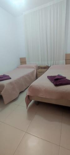 two beds in a room with white tile floors at Cala Blanca on the beach in El Borseral