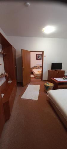 a room with a bedroom with a bed and a desk at Penzión Stefanie in Vinné
