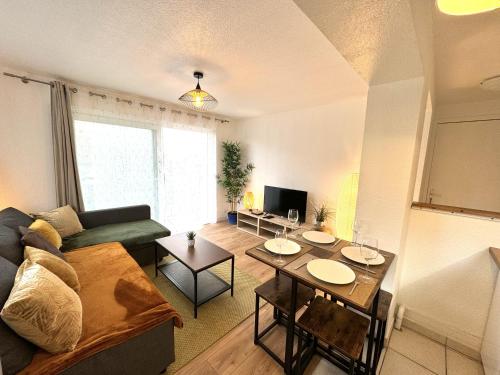 a living room with a couch and a table at Le Golden Lake-5min du LAC à pied-Parking privé gratuit in Sévrier