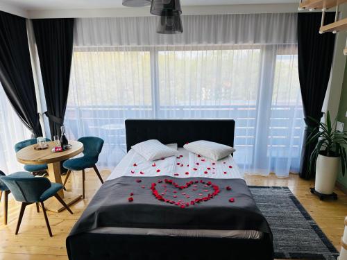 a bedroom with a bed with a red heart on it at Pensiunea Senin in Sovata