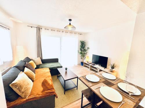 a living room with a couch and a table at Le Golden Lake-5min du LAC à pied-Parking privé gratuit in Sévrier