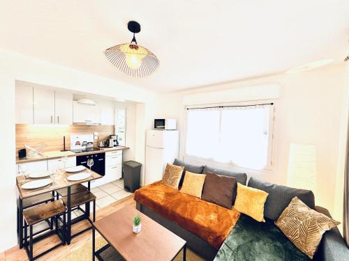 a living room with a couch and a kitchen at Le Golden Lake-5min du LAC à pied-Parking privé gratuit in Sévrier