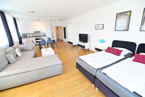 シュヴェリーンにあるAm Schloss 106のベッド2台とソファのあるリビングルーム