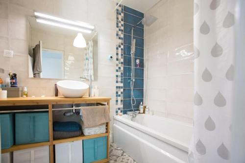 La salle de bains est pourvue d'une baignoire blanche, d'un lavabo et d'une baignoire. dans l'établissement HOSSEGOR, T3 avec jardin entre Lac et Océan, à Soorts-Hossegor