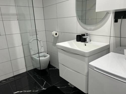 Un baño blanco con lavabo e inodoro. en Emma, en Bar