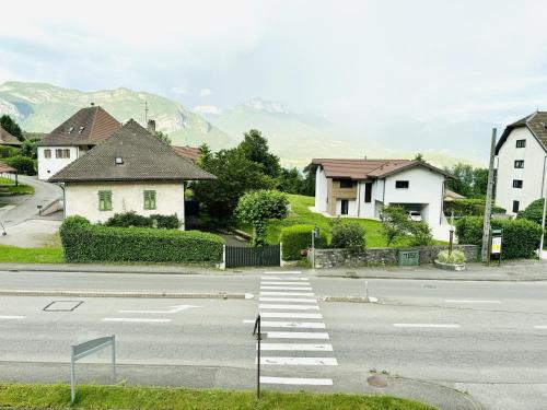 an empty street with houses and a crosswalk at Le Golden Lake-5min du LAC à pied-Parking privé gratuit in Sévrier