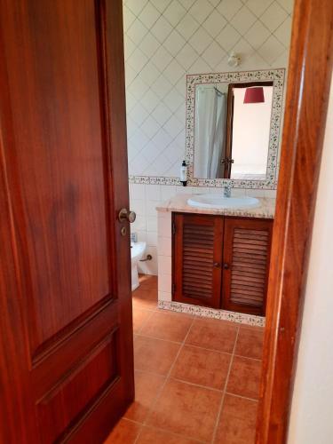 a bathroom with a sink and a mirror at Vicentina Rooms - Duna Parque Group in Vila Nova de Milfontes