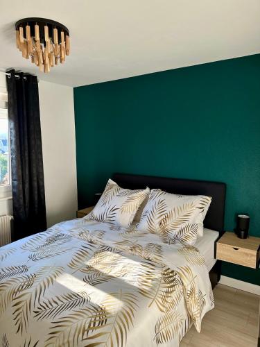 Ce lit se trouve dans une chambre dotée d'un mur vert. dans l'établissement Flori'Home, à Colmar