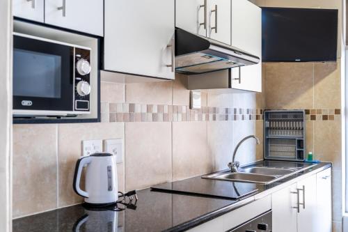 a kitchen with a sink and a microwave at ATKV Natalia in Kingsburgh