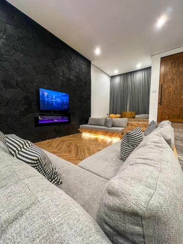 a living room with a couch and a tv at LeRoca Villa in Bandung