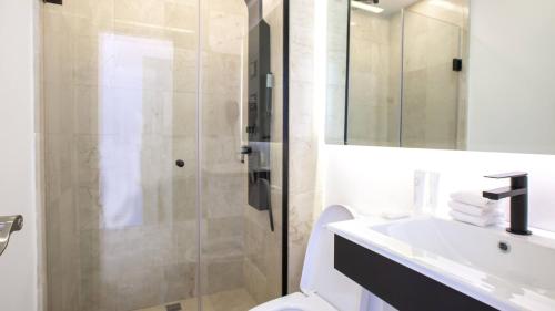 a bathroom with a shower and a sink and a toilet at Cana Rock Condos in Punta Cana