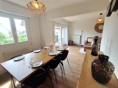 a dining room with a table with glasses on it at Le Balnéo Duplex avec balcon - Riva Bella Plage in Ouistreham