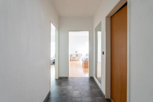 a hallway with white walls and a wooden door at FarawayHomes Studio Kapfenberg #7 in Kapfenberg