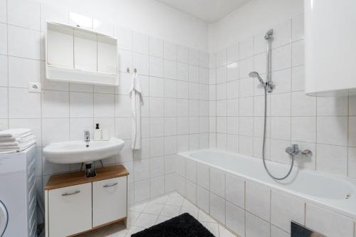 a white bathroom with a sink and a bath tub at FarawayHomes Studio Kapfenberg #7 in Kapfenberg